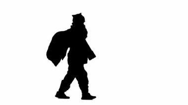 Noel ve yeni yıl tatili konsepti. Beyaz izole edilmiş arka planda, Noel Baba kostümlü bir adamın siyah silueti. Noel Baba sırtında bir torba hediyeyle neşeli bir şekilde yürür. Yan görünüm