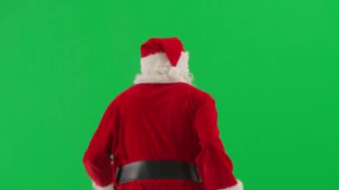 Noel ve Yeni Yıl yaratıcı konsepti. Krom anahtar yeşil ekranda Noel Baba kılığında bir adam portresi. Kırmızı kıyafetli, sakallı ve bıyıklı Noel Baba.