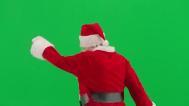 Noel ve Yeni Yıl yaratıcı konsepti. Krom anahtar yeşil ekranda Noel Baba kılığında bir adam portresi. Kırmızı elbiseli Noel Baba komik dans ediyor..