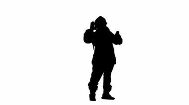 Noel ve yeni yıl tatili konsepti. Beyaz izole arka planda, Noel Baba kostümlü bir adamın siyah silueti. Noel Baba video konuşmasında akıllı telefon kullanıyor.