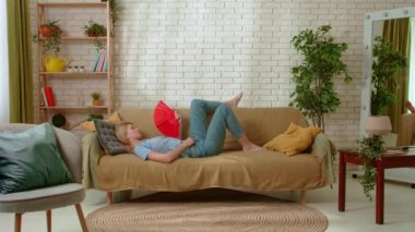 Genç bir bayan evde vakit geçiriyor. Genç milenyum kadını oturma odasındaki kanepede uzanmış vantilatör sallıyor, yaz sıcağıyla klimasız başa çıkıyor. Sıkıcılık günlük yaşam konsepti.