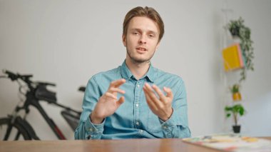 Çevrimiçi kursa katılan genç kişi. Erkek üniversite öğrencisi evde çalışıyor, masada oturuyor, öğretmenle konuşuyor, soruları cevaplıyor, internette dinleme dersi alıyor. Modern online eğitim