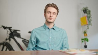 Çevrimiçi kursa katılan genç kişi. Erkek üniversite öğrencisi evde çalışıyor, masada oturuyor, kafası karışık ifadelere cevap veriyor, internette dinleme dersi veriyor. Modern online eğitim