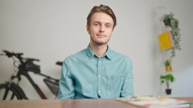 Çevrimiçi kursa katılan genç kişi. Erkek üniversite öğrencisi evde çalışıyor, masada oturuyor öğretmenle konuşuyor ve soruları cevaplıyor, internette dinleme dersi veriyor. Modern online eğitim