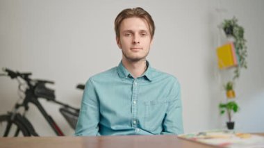 Çevrimiçi kursa katılan genç kişi. Erkek üniversite öğrencisi evde çalışıyor, masada oturuyor öğretmenle konuşuyor ve soruları cevaplıyor, internette dinleme dersi veriyor. Modern online eğitim