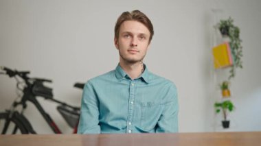 Çevrimiçi kursa katılan genç kişi. Erkek üniversite öğrencisi evde çalışıyor, masada oturuyor, internette dersini dinliyor ve izliyor, kafa sallıyor. Modern online eğitim.