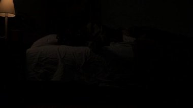 Genç bir bayan karanlıkta evde kestiriyor. Karanlık bir dairede yatakta uyuyan bir kadın, yatağın altında saklanan bir canavar, kızların eline dokunmak için sürünen korkunç bir el. Dışarıda fırtına var. Cadılar Bayramı korku konsepti.