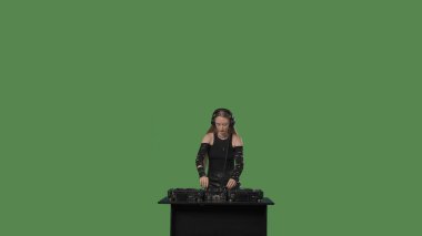 Konsolda siyah giyinmiş, şarkıları karıştıran ve ritmik müzikle dans eden bir kadın DJ 'in dinamik videosu. Kalabalıkla enerjik bir şekilde etkileşime geçiyor, yeteneğini ve müziğe olan tutkusunu gösteriyor..