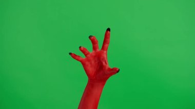 Stüdyoda jestler gösteren korkunç bir el. Korkunç cadılar bayramı canavarı kırmızı boyalı siyah tırnaklı el, sürünerek yakalandığını gösteriyor. Krom anahtar yeşil ekran arka planında izole edilmiş, çalışma alanı modeli..