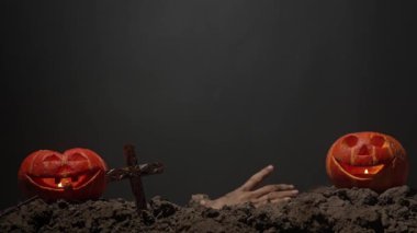 Korkunç canavar el, mezarlıkta jestler gösteriyor. Mezardan yükselen korkunç cadılar bayramı zombi eli toprağa dokunuyor, siyah arka planda izole edilmiş. Gizemli Cadılar Bayramı konsepti.