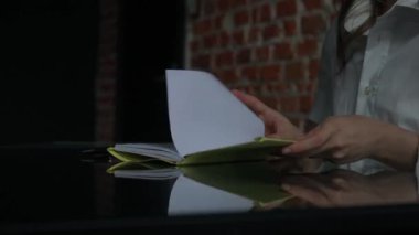 Kağıt üzerinde kadın metni. Ofis masasında oturan bir iş kadını süt ürünleri bölümünde kalemle notlar açıp yazıyor. Konsantre bir kişi fikirler ve görevler yazıyor. Yakın çekim..