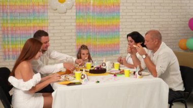 Mutlu çok nesilli bir aile doğum gününü kendi evinde kutlar. Masadaki herkes şenlikli bir akşam yemeği yerken neşeli bir sohbete daldı. Parti ve kutlama konsepti..