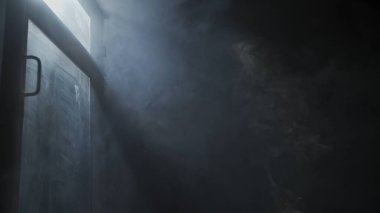 Yumuşak yayılmış ışık huzmeleri sisli karanlığı ve pencereyi aydınlatır. Spot ışığından gelen ışık karanlık bir alanda duman bulutlarını aydınlatır. Sinematik ışık.