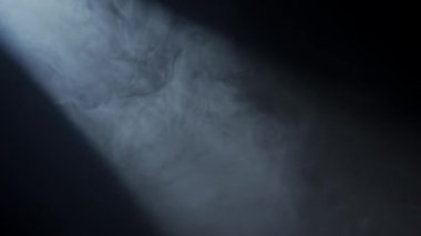 Yumuşak yayılmış ışık ışınları puslu karanlığın içinden geçiyor. Spot ışığının yan ışığı ya da spot ışıkları karanlık bir alanda duman bulutlarını aydınlatır. Sinematik ışık.