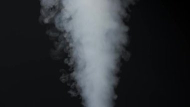 Siyah arka planda beyaz duman bulutlarının yakın çekimi. Parlak duman ve karanlık odanın tam tersi. Sinematografik ışık