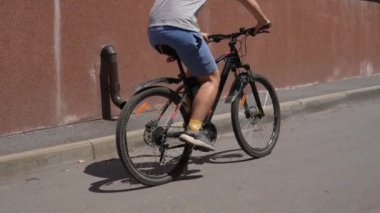 Şehirdeki asfalt yolda bisiklet süren bir adam. Güneşli bir yaz gününde bisiklet gezisi. Sağlıklı yaşam tarzı