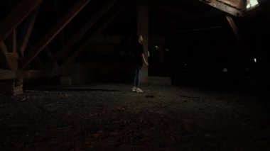 Karanlıkta çatıda korkunç deli bir palyaço. Karanlık tavan arasında korkmuş genç bir kadın. Makyajlı çılgın katil palyaço. Bıçakla duruyor ve deli gibi gülümseyen bir kadına doğru yürüyor. Cadılar Bayramı gerilim konsepti.