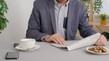 Hizmet ya da ürün için farklı ödeme türleri kullanan bir adam. Kafe restoranındaki masada oturan adam gazete okuyor. Ticari iş ödemeleri.