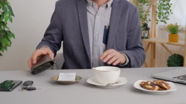 Hizmet ya da ürün için farklı ödeme türleri kullanan bir adam. Kafe restoranında masada oturan adam cüzdanı açar ve nakit para ile faturayı öder. Ticari iş ödemeleri.