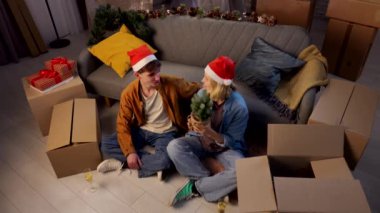 Genç çift yeni evine taşınıyor. Noel Baba şapkalı bir adam ve bir kadın yeni dairede yeni yıl partisi veriyor, kutulardan kutuları açıyor, konuşuyor ve gülümsüyor..