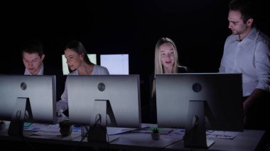 Yönetim kurulu başkanı ve ekibi ofiste çalışıyor. Erkek ve kadın liderler, masalarda monitörlerle, yıl sonu kurumsal toplantılarında, genç üyelerle birlikte çalışırlar..