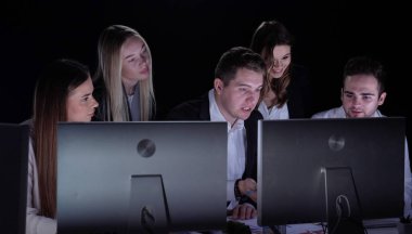 Yönetim kurulu başkanı ve ekibi ofiste çalışıyor. Kadın ve erkek liderler karanlık ofiste monitörlerle, yıl sonu şirket toplantılarında, üyeler patronla iletişim kurarken, ekrana bakarken, yan çekimlere bakarken,.