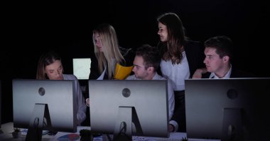 Yönetim kurulu başkanı ve ekibi ofiste çalışıyor. Erkek ve kadın liderler karanlık ofiste gözlemcilerle, yıl sonu kurumsal toplantılarında masa başında çalışırlar. Patron takım üyelerine bakar çalışma kağıtlarını tartışır..