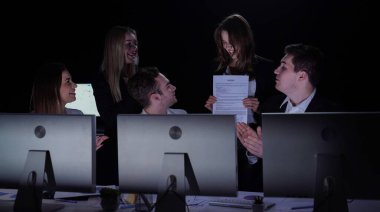 Yönetim kurulu başkanı ve ekibi ofiste çalışıyor. Kadın ve erkek liderler masalarında monitörlerle, yıllık şirket toplantılarıyla, patronlarına ve takım üyelerine gülümseyen kontrat kağıtlarını gösteriyorlar..