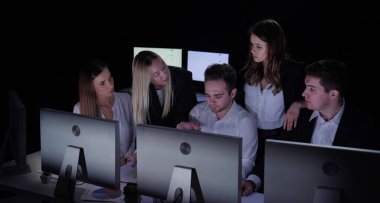 Yönetim kurulu başkanı ve ekibi ofiste çalışıyor. Kadın ve erkek liderler masalarda monitörlerle, yıllık şirket toplantılarında çalışırlar. Patron takım üyelerinin iş konuşmalarına bakar..