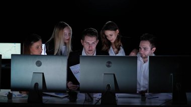 Yönetim kurulu başkanı ve ekibi ofiste çalışıyor. Kadın ve erkek liderler karanlık ofiste monitörlerle, yıl sonu şirket toplantısıyla, patron kağıtları elinde tutarak ekranlara bakar, üyelerin yanında dururlar..