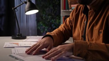 Ofis çalışanı fazla mesai yapıyor. Genç iş adamı gece geç saatlere kadar masa başında çalışıyor, mali bilgili kağıt dökümanlarına bakıyor, verileri kontrol ediyor..