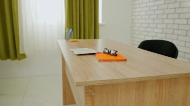 Ekipman ve mobilyalarla dolu üniversite sınıfı. Gün ışığında masaları, sandalyeleri ve tahtası olan boş bir ilkokul sınıfı, öğretmek için çalışma alanı. Not defteri ve gözlükler öğretmenler masasında..