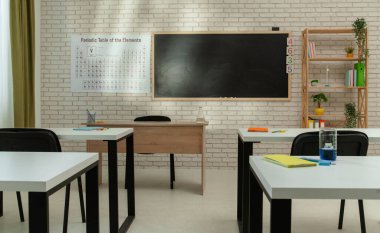 Ekipman ve mobilyalarla dolu üniversite odası. Masaları, sandalyeleri ve tahtası olan boş bir kimya sınıfı. Eğitim ve öğretim için çalışma alanı. Masalarda sıvı bulunan cam şişeler, orta boy..