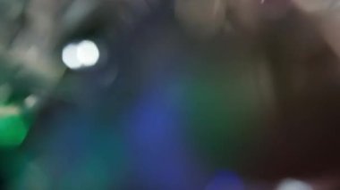 Renkli ışık sızıntısı. Bulanık renkli lensler, hareketli stüdyo yıldırımları, arka planda bokeh etkisi olan çelenkler. Işık sızıntıları etrafta yanıp sönüyor, soyut arkaplan görüntüleri.