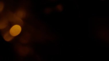 Renkli ışık sızıntısı. Bulanık sarı lens, hareket stüdyosu yıldırımı koyu arkaplan üzerinde bokeh etkisi olan çelenk. Işık etrafta dolaşıyor, soyut arkaplan görüntüleri.