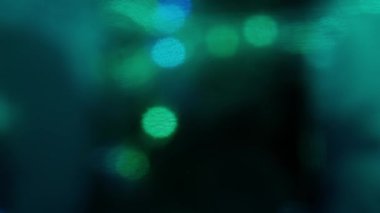 Renkli ışık sızıntısı. Bulanık mavi lens, hareket stüdyosu yıldırımı, koyu arkaplan üzerinde bokeh etkisi olan çelenk. Işık yanıp sönüyor, soyut arkaplan görüntüleri.