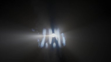 Sis stüdyosunda beyaz ışık huzmeleri. Siyah arkaplanda yanıp sönen parlak, beyaz ışık huzmeleri. İçinden duman yükseliyor, tam kare..