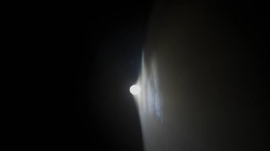 Sis stüdyosunda beyaz ışık huzmeleri. Profesyonel ışıklandırma ekipmanlarının parlak beyaz ışıkları sağ köşedeki siyah arka planda yanıp sönüyor ve dumanlar yükseliyor..