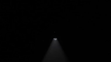 Sis stüdyosunda beyaz ışık huzmeleri. Parlak beyaz spot ışıkları profesyonel ışıklandırma ekipmanları yanıp sönüyor. Karanlıkta dumanla dönüyor. Işık yavaşça aşağıdan yukarıya doğru hareket ediyor..