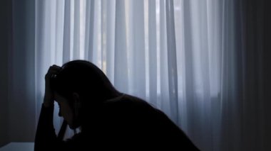 Karanlıkta odada yalnız bir kadın. Kadın silueti pencerenin önünde masada oturuyor, bitkin bir ifade, depresyon ve pişmanlık, şüphe ve umutsuzluk. İnsan duyguları ve akıl sağlığı.