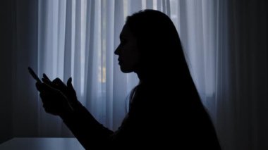 Karanlıkta bir odada yalnız bir kadın. Kadın silueti pencerenin önünde, akıllı telefona, dramaya ve krize, zihinsel acıya bir mesaj yazıyor. İnsan duyguları ve akıl sağlığı.