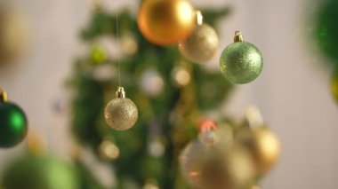 Yeni yıl dekorasyonları. Noel ağacı, altın, gümüş ve yeşil toplar, yukarıdan sarkan parlak renkli oyuncaklar, ışıltılı süsler yakın çekim için şenlikli arka plan..