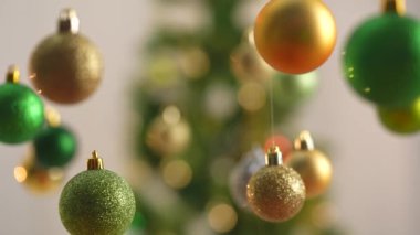 Yeni yıl dekorasyonları. Noel ağacı, altın, gümüş ve yeşil toplar, yukarıdan sarkan parlak renkli oyuncaklar, ışıltılı süsler yakın çekim için şenlikli arka plan..