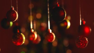 Yeni yıl dekorasyonları. Noel ağacı yeşili toplar kırmızı neon ışıkla vurgulanır. Tepesinden sarkan ışıltılı süsler. Yakın plan şenlik arkaplanına yakın çekim..