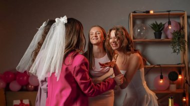 Düğün öncesi sevgililer partisi. Bir grup genç bayan arkadaş ve gelin evde bekârlığa veda partisini kutluyorlar. Kızlar evlilik yüzüklerini gösteriyorlar. Heyecanlı bir gülümseme..