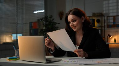 Yetişkin bölük lideri fazla mesai yapıyor. Genç bir iş kadını geç saatlere kadar masa başında çalışır, dizüstü bilgisayar kullanır, belgelere bakar, mutlu bir ifadeyle tatmin olur..