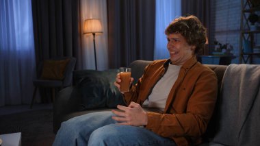 Adam evde boş vakit geçiriyor. Genç adam akşamını evde, kanepede oturup televizyon izleyerek, hayal kırıklığına uğramış meyve suyu içerek ve iğrenç bir tat alarak geçiriyor..