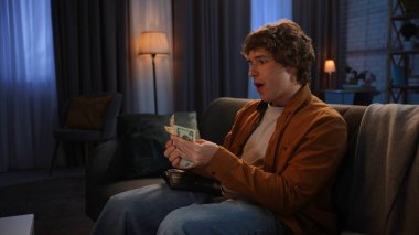 Adam evde boş vakit geçiriyor. Genç bir adam geceyi evde, kanepede oturarak, cüzdanını açarak, nakit para tutarak, banknotları sayarak, vay canına tatmin olmuş bir ifadeyle geçirir..