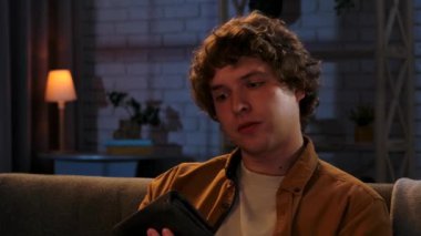 Adam evde boş vakit geçiriyor. Genç adam geceyi evde, oturma odasında koltukta oturarak, cüzdanını açıp para arıyor, birkaç nakit para çekiyor, hayal kırıklığına uğramış yüz ifadesini bozuyor, kapatıyor..