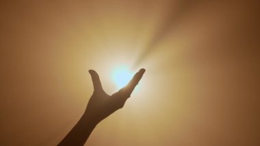 El hareketleri ve işaretleri. El silueti jest gösteriyor, parlak altın renkli spot ışıklarına ışık tutan bir işaret yapıyor, stüdyo arka planında izole edilmiş, yakın plan çekimi..